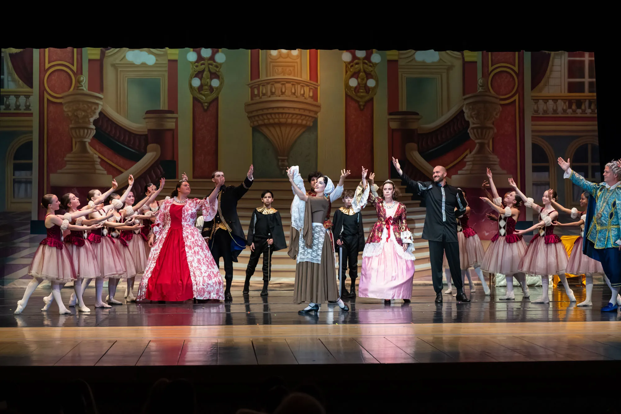 A cast in costume lined up across the stage for a bow